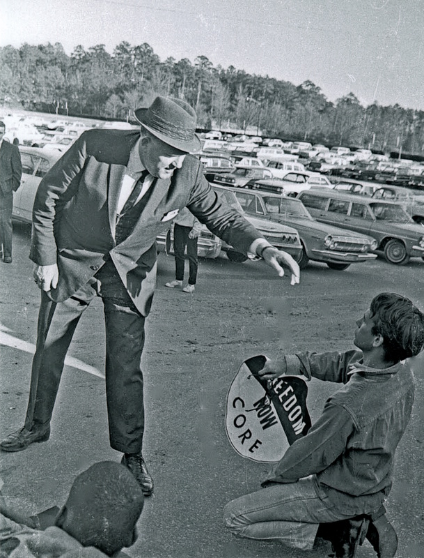 Arthur Beaumont reaches for a demonstrator blocking the entrance to the Woollen Gym parking lot.