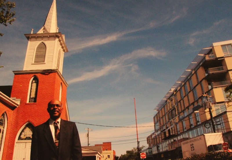 Dr. Reginald Hildebrand, a professor of African-American Studies at UNC and long-time member of St. Paul’s A.M.E., stands in front of his church and the new Greenbridge development, 2010.